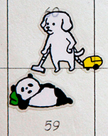 座布団を枕にして頬杖をつきごろりと寝転んだパンダのシールの背後に、掃除機をかけている犬のシールを組み合わせて、掃除の邪魔になっているひとのように見せた作品