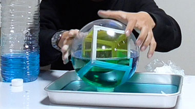 球体に立方体を内接して水を注いで観察する様子